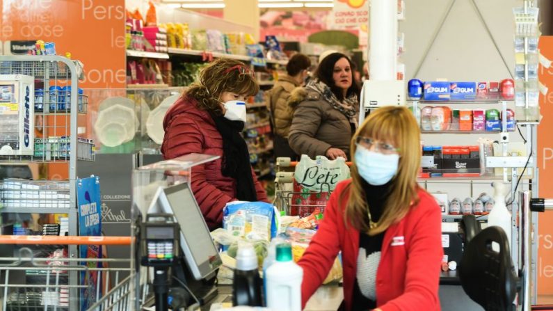 Los residentes que usan máscaras respiratorias compran en un supermercado en pequeños grupos de cuarenta personas el 23 de febrero de 2020 en la pequeña ciudad italiana de Casalpusterlengo, a la sombra de un nuevo brote de coronavirus, mientras Italia tomaba medidas drásticas de contención al aumentar el temor mundial por la epidemia. (MIGUEL MEDINA/AFP/Getty Images)