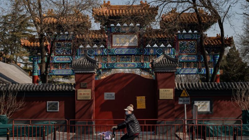 Una mujer con una máscara protectora para protegerse contra los ciclos de coronavirus COVID-19 frente al Templo Lama en Beijing, China, el 23 de febrero de 2020. (NICOLAS ASFOURI/AFP a través de Getty Images)