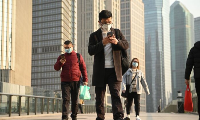 Personas con máscaras protectoras caminan en un paso elevado en Shangai el 24 de febrero de 2020. (Noel Celis/AFP a través de Getty Images)