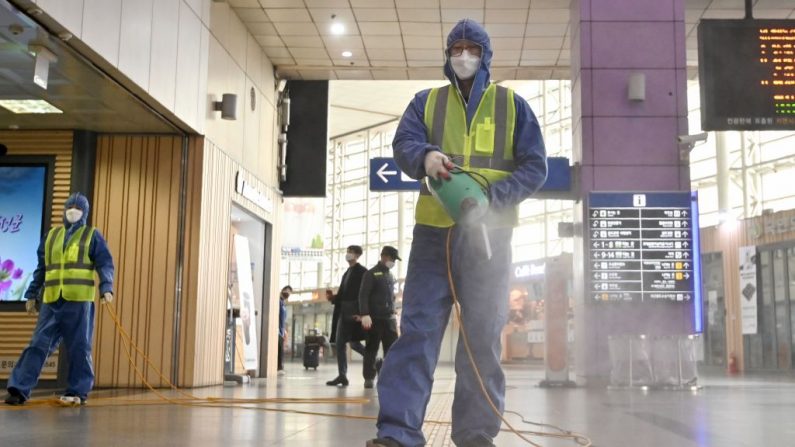 Un trabajador con equipo de protección rocía desinfectante como parte de las medidas preventivas contra la propagación del coronavirus COVID-19, en una estación de ferrocarril en Daegu el 26 de febrero de 2020.  (Foto de Jung Yeon-je / AFP) (Foto de JUNG YEON-JE/AFP a través de Getty Images)
