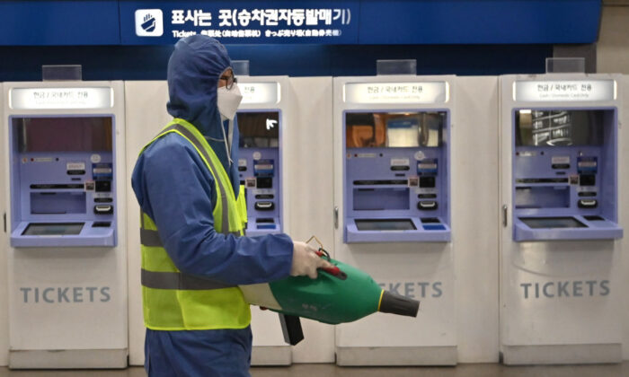 Un trabajador con equipo de protección rocía desinfectante como parte de las medidas preventivas contra la propagación del nuevo coronavirus en una estación de ferrocarril en Daegu, Corea del Sur, el 26 de febrero de 2020. (Jung Yeon-je/AFP vía Getty Images)