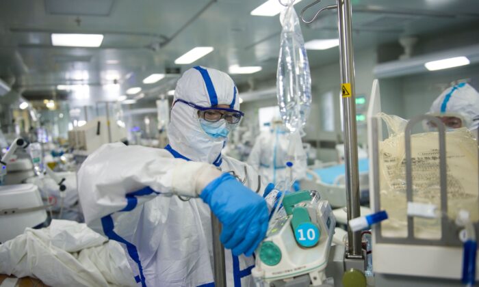 Una enfermera está operando un equipo en una unidad de cuidados intensivos que trata a pacientes con coronavirus COVID-19, en un hospital en Wuhan, China, el 22 de febrero de 2020. (STR/AFP a través de Getty Images)