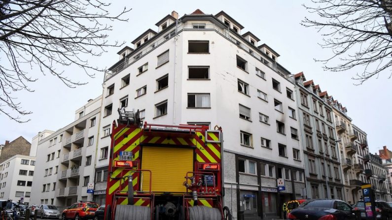 Los bomberos franceses se paran frente a un edificio dañado en Estrasburgo (Francia) el 27 de febrero de 2020, la mañana después de un incendio. (PATRICK HERTZOG/AFP/Getty Images)