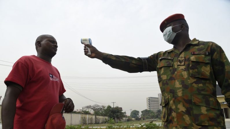 Un soldado comprueba la temperatura corporal de un visitante del Hospital de Referencia del Ejército de Nigeria 68 en Yaba en Lagos, el 28 de febrero de 2020.  (PIUS UTOMI EKPEI/AFP vía Getty Images)