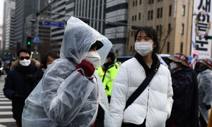 La gente usa máscaras para evitar el nuevo coronavirus paseando por la calle en Seúl, Corea del Sur, el 22 de febrero de 2020. (Chung Sung-Jun/Getty Images)
