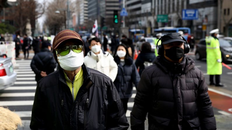 La gente usa máscaras para prevenir el contagio por coronavirus (COVID-19) en la calle el 22 de febrero de 2020 en Seúl, Corea del Sur. (Chung Sung-Jun/Getty Images)