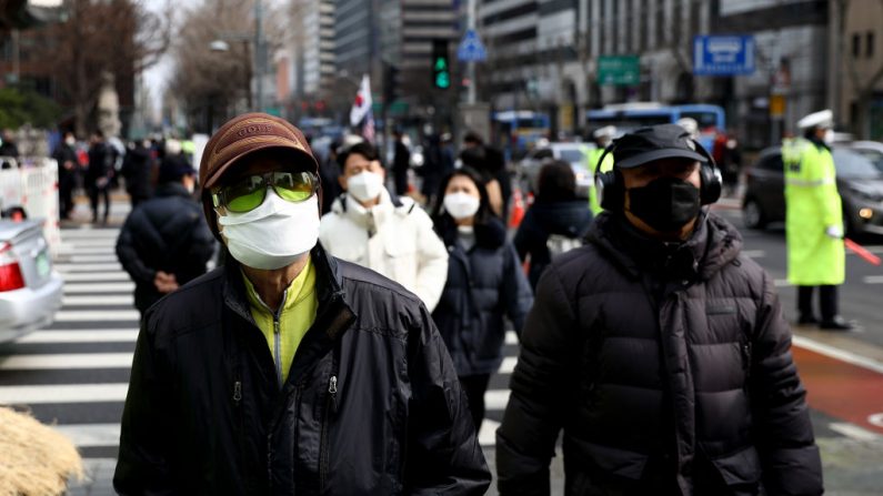 La gente usa máscaras para prevenir el coronavirus COVID-19 el 22 de febrero de 2020 en Seúl, Corea del Sur. (Chung Sung-Jun/Getty Images)