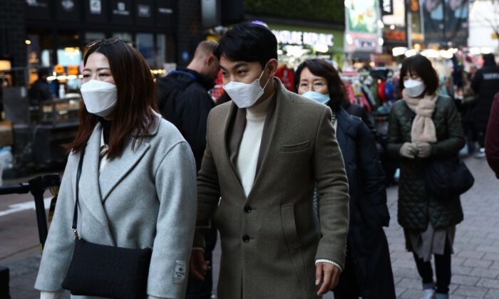 Personas con mascarillas faciales para prevenir el novedoso coronavirus caminan a lo largo del distrito comercial Myungdong en Seúl, Corea del Sur, el 23 de febrero de 2020. (Chung Sung-Jun/Getty Images)