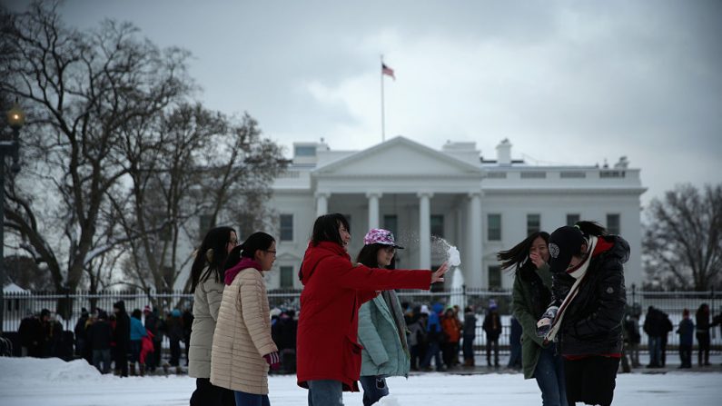 Turistas chinos de Pekín participan en una pelea de bolas de nieve frente a la Casa Blanca el 17 de febrero de 2015 en Washington, DC. (Foto de Alex Wong/Getty Images)
