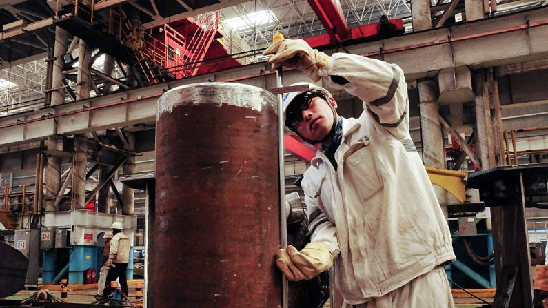 Un trabajador chino mide un oleoducto en una plataforma de perforación petrolífera en Qingdao, en la provincia de Shandong, al este de China, el 1 de abril de 2016. ( STR/AFP a través de Getty Images)
