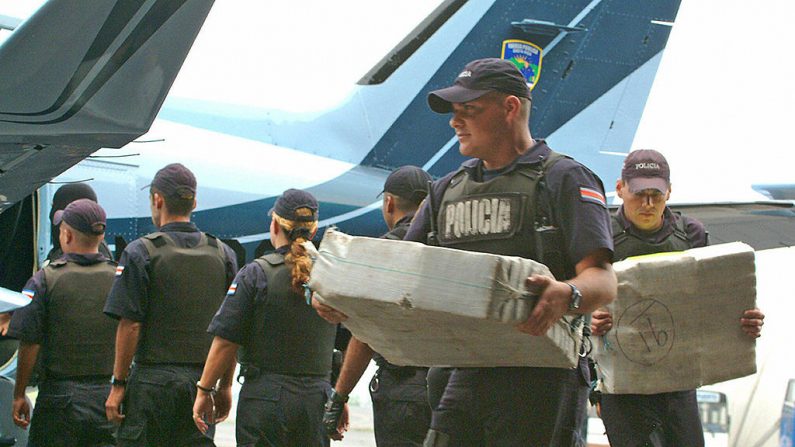 Miembros de la policía costarricense descargan en el aeropuerto Juan Santamaría de Alajuela, a 20 km de San José, un cargamento de cocaína incautado. (STR/AFP vía Getty Images)