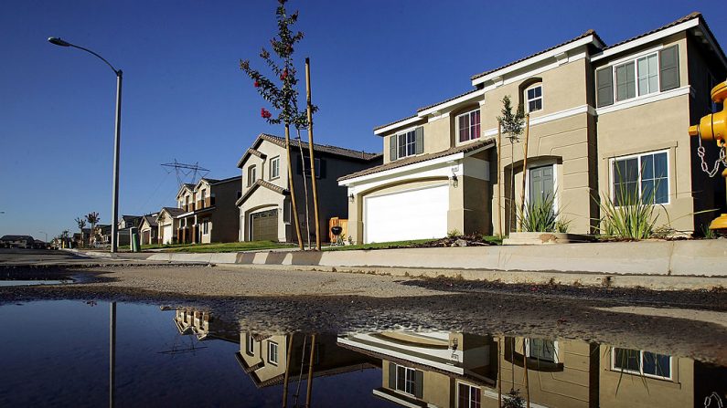 Las casas nuevas se reflejan en el agua que se ha desbordado de los rociadores de césped en una urbanización el 28 de julio de 2005 en Hesperia, California. (David McNew/Getty Images)