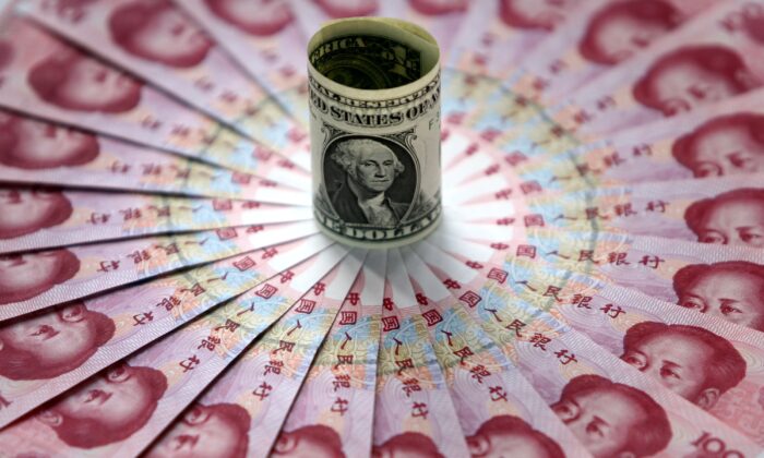 Un billete de un dólar junto a billetes de 100 yuanes en un banco de Beijing (China) el 15 de mayo de 2006. (China Photos/Getty Images)