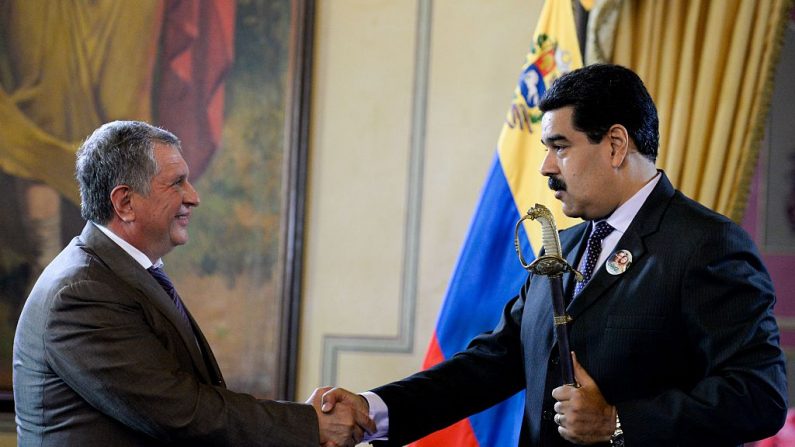 El presidente venezolano Nicolás Maduro (R) da la mano al director general de la petrolera rusa Rosneft, Igor Sechin (L), durante la firma de acuerdos en el Palacio Presidencial de Miraflores en Caracas el 28 de julio de 2016. (Imagen FEDERICO PARRA/AFP vía Getty Images)
