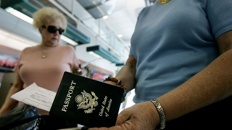 Los viajeros sacan sus pasaportes antes de registrarse en el aeropuerto internacional de San Diego el 8 de enero de 2006 en San Diego, California. (Imagen ilustrativa de Sandy Huffaker/Getty Images)
