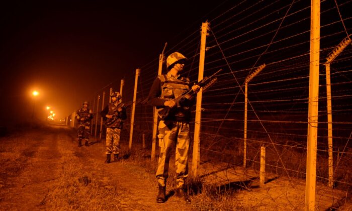 Un grupo de soldados de la Fuerza de Seguridad Fronteriza de India (BSF) patrulla a lo largo de la valla de la frontera entre India y Pakistán en Suchit-Garh, 36 kilómetros al suroeste de Jammu, el 11 de enero de 2013. (Tauseef Mustafa/AFP vía Getty Images)