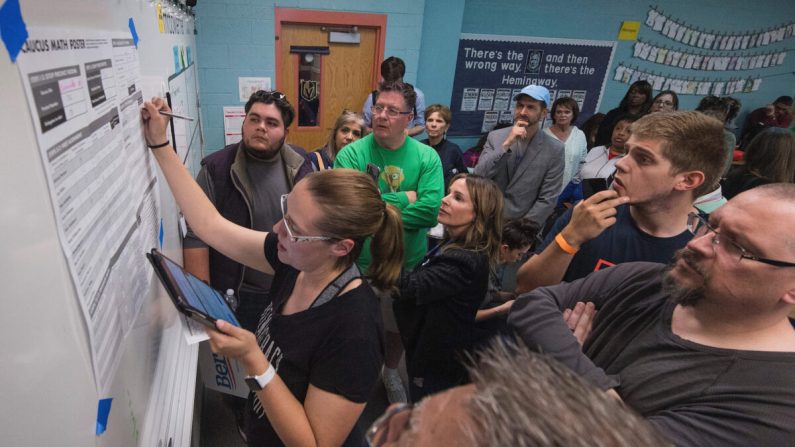 Votantes observan mientras un voluntario cuenta los votos durante las asambleas de Nevada para nominar a un candidato presidencial demócrata en la mesa electoral dentro de la Escuela Secundaria Coronado en Las Vegas, Nevada, el 22 de febrero de 2020. (MARK RALSTON/AFP a través de Getty Images)