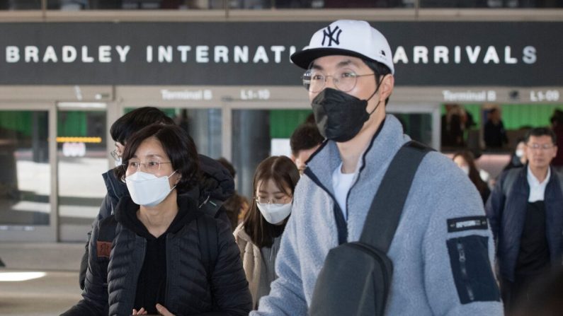 Los pasajeros usan máscaras protectoras para protegerse contra la propagación del coronavirus cuando llegan en un vuelo desde Asia al Aeropuerto Internacional de Los Ángeles, California, el 29 de enero de 2020. (Mark Ralston/AFP a través de Getty Images)
