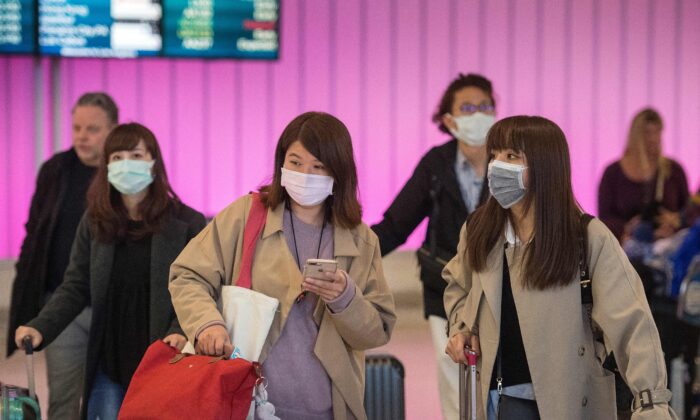 Pasajeros llevan máscaras protectoras para protegerse de la propagación del coronavirus cuando llegan al Aeropuerto Internacional de Los Ángeles, California, el 22 de enero de 2020. (Mark Ralston/AFP vía Getty Images)