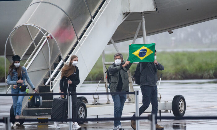 Ciudadanos brasileños procedentes de la ciudad china de Wuhan aterrizan y desembarcan en la base de la Fuerza Aérea de Anápolis, Estado de Goias, Brasil, el 9 de febrero de 2020. (Andressa Anholete / Getty Images)

