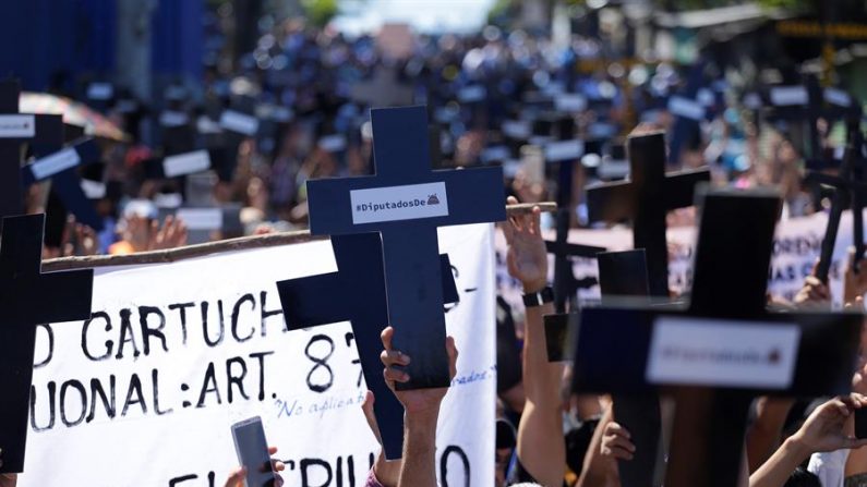 Simpatizantes del presidente salvadoreño Nayib Bukele protestan este domingo en las afueras del Congreso para exigir a los diputados que aprueben un préstamo para seguridad pública, en San Salvador (El Salvador). EFE/Rodrigo Sura
