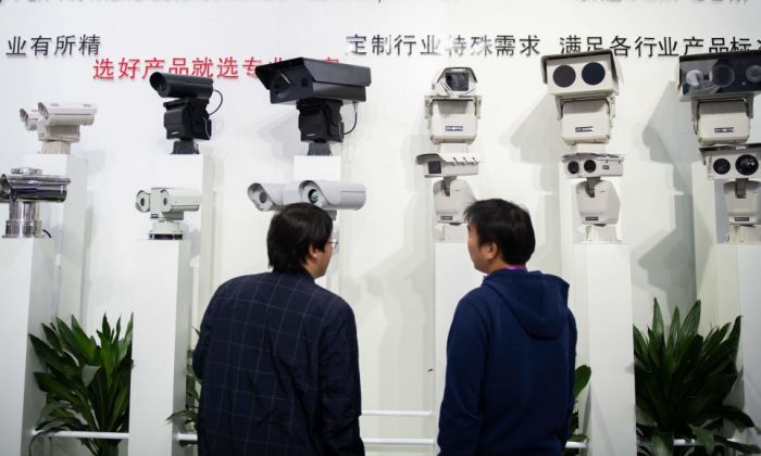 Unos visitantes miran las cámaras de seguridad de inteligencia artificial que utilizan la tecnología de reconocimiento facial en la 14ª Exposición Internacional de China sobre Seguridad Pública en el Centro Internacional de Exposiciones de China en Beijing, el 24 de octubre de 2018. (Nicolas Asfouri/AFP/Getty Images)