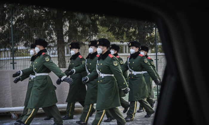 Marcha de la policía china con máscaras durante un cambio de funciones en Beijing, China, el 3 de febrero de 2020. (Kevin Frayer / Getty Images)