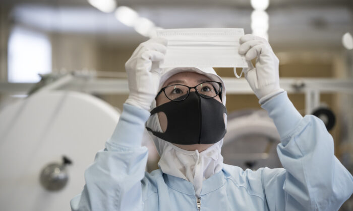 Un empleado inspecciona una máscara facial desechable en la línea de producción de la compañía Yokoi. Ltd. en Nagoya, Japón, el 6 de febrero de 2020. (Tomohiro Ohsumi/Getty Images)