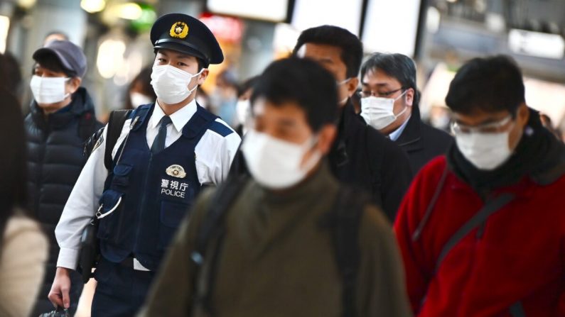 Personas vestidas con máscaras se dirigen al trabajo durante la hora punta de la mañana en la estación de trenes de Shinagawa en Tokio, Japón, el 28 de febrero de 2020. (Charly Triballeau/AFP vía Getty Images)