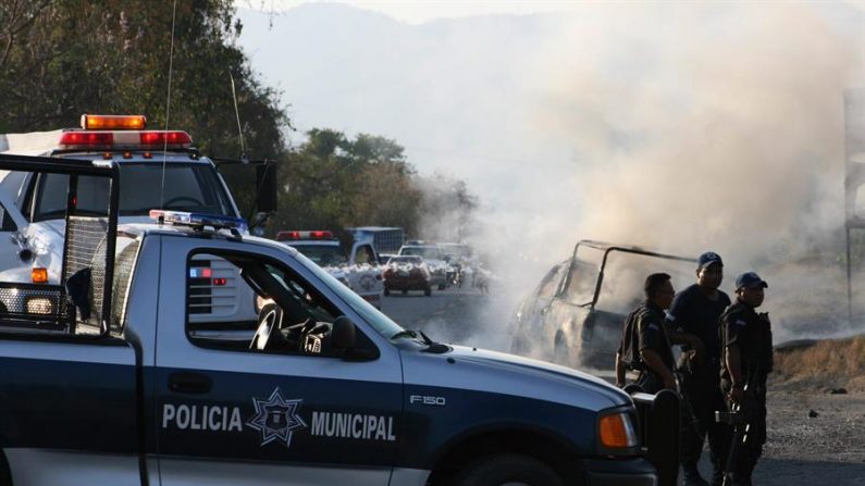 Miembros de la policía resguardan la camioneta en la que cuatro policías municipales murieron el 25 de febrero de 2009, calcinados en la localidad de Zihuatanejo, del sureño estado mexicano de Guerrero. EFE/Felipe Salinas/Archivo
