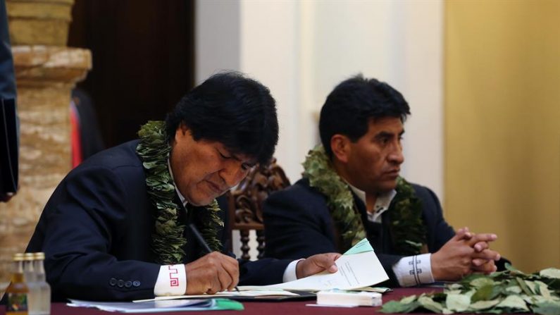 El presidente de Bolivia, Evo Morales (i), acompañado del ministro de Desarrollo Rural y Tierras, Cesar Cocarico (d), firma la Ley de la Coca el 8 de marzo de 2017, en La Paz (Bolivia). EFE/Martin Alipaz/Archivo
