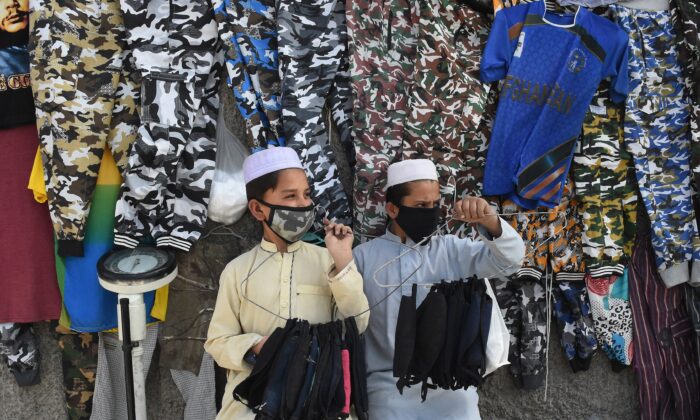 Vendedores de mascarillas usan mascarillas de protección como medida de prevención contra el coronavirus COVID-19 a lo largo de una calle en Quetta, Pakistán, el 27 de febrero de 2020. El país reportó sus primeros casos confirmados. (Banaras Khan/AFP vía Getty Images)