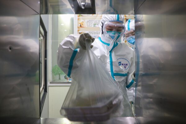 Personal médico recibiendo cajas de almuerzo para los pacientes a través de una ventana en una sala de aislamiento de un hospital de Wuhan en la provincia central de Hubei, China, durante el brote de virus en la ciudad, el 30 de enero de 2020. (STR/AFP vía Getty Images)