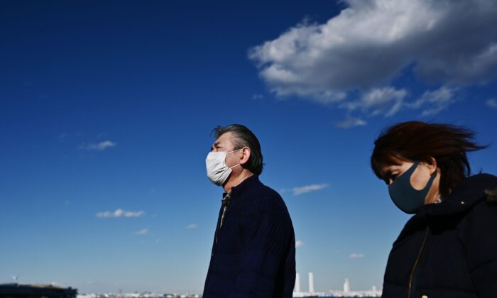 Personas con máscaras faciales caminan por la costa en Yokohama, Japón, el 18 de febrero de 2020. (Charly Triballeau/AFP a través de Getty Images)