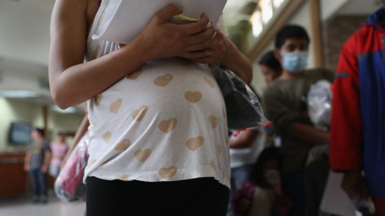 Una inmigrante hondureña embarazada hace fila junto a sus compañeros para tomar un autobús hacia un destino en EE.UU. el 15 de agosto de 2016 desde McAllen, Texas. (John Moore/Getty Images)