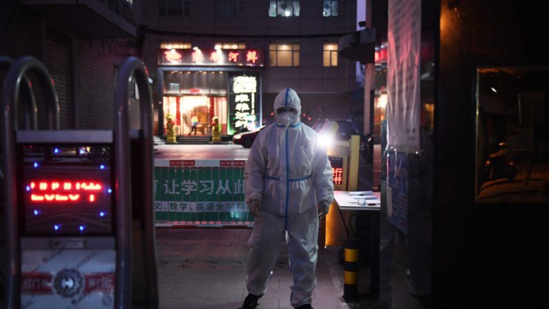 Un guardia de seguridad usa ropa protectora como medida preventiva contra el virus COVID-19 en la entrada de un restaurante en Beijing el 25 de febrero de 2020. (Greg Baker/AFP a través de Getty Images)