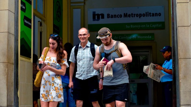 Los turistas dejan un banco después de cambiar dinero en La Habana, el 10 de diciembre de 2019. (YAMIL LAGE/AFP vía Getty Images)