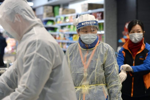 Un miembro del personal que lleva una máscara y un traje de protección trabaja en un supermercado de Wuhan, el epicentro del brote del nuevo coronavirus, en la provincia central de Hubei en China, el 10 de febrero de 2020. (AFP a través de Getty Images)