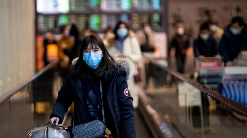 Una pasajera que lleva una mascarilla protectora mira mientras llega al Aeropuerto Internacional de Beijing el 2 de febrero de 2020. (Noel Celis/AFP vía Getty Images)