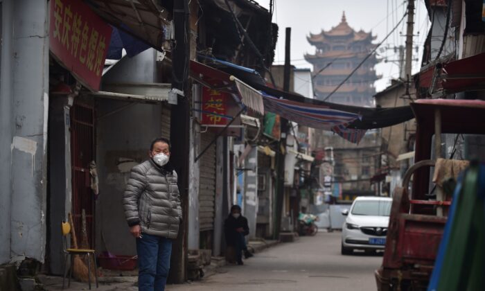 Un hombre usa una máscara facial como medida preventiva contra el coronavirus COVID-19 en un callejón de Wuhan, en la provincia central de Hubei, China, el 26 de febrero de 2020. (STR/AFP a través de Getty Images)
