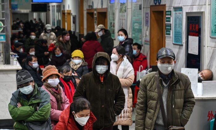 Ciudadanos usan mascarillas para ayudar a detener la propagación del virus del PCCh mientras esperan atención médica en el Hospital de la Cruz Roja de Wuhan, China, el 25 de enero de 2020. (Hector Retamal/AFP vía Getty Images)