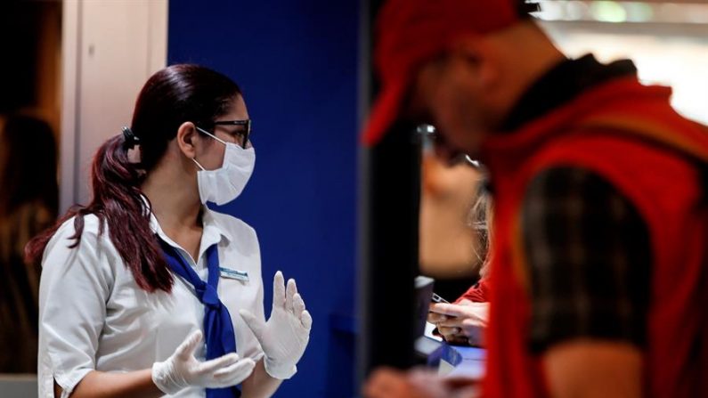 Fotografía del 4 de marzo que muestra a pasajeros y empleados del Aeropuerto de Ezeiza con tapabocas, tras la confirmación del primer caso del Coronavirus en el país, en Buenos Aires (Argentina). EFE/ Juan Ignacio Roncoroni
