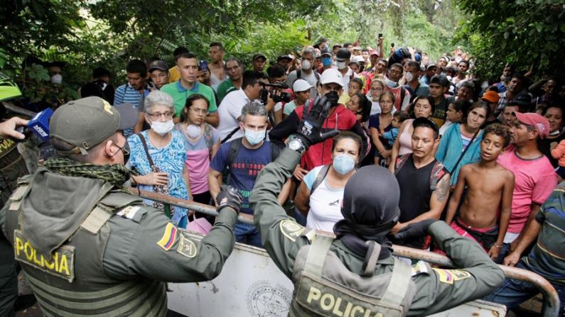 Policías colombianos fueron registrados este domingo al organizar la salida de venezolanos hacia su país, por uno de los pasos fronterizos en Cúcuta (Colombia), tras el anuncio del Gobierno colombiano de cerrar su frontera con Venezuela, como medida de mitigación a la propagación del virus del PCCh. EFE/Str
