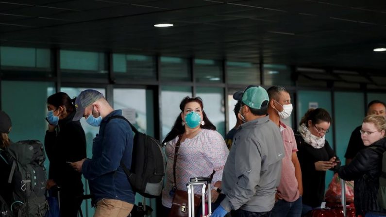 Ciudadanos estadounidenses esperan afuera del aeropuerto la Aurora de Guatemala esperando su ingreso a aviones que los regresarán a su país, este lunes, en Ciudad de Guatemala (Guatemala). EFE/Esteban Biba
