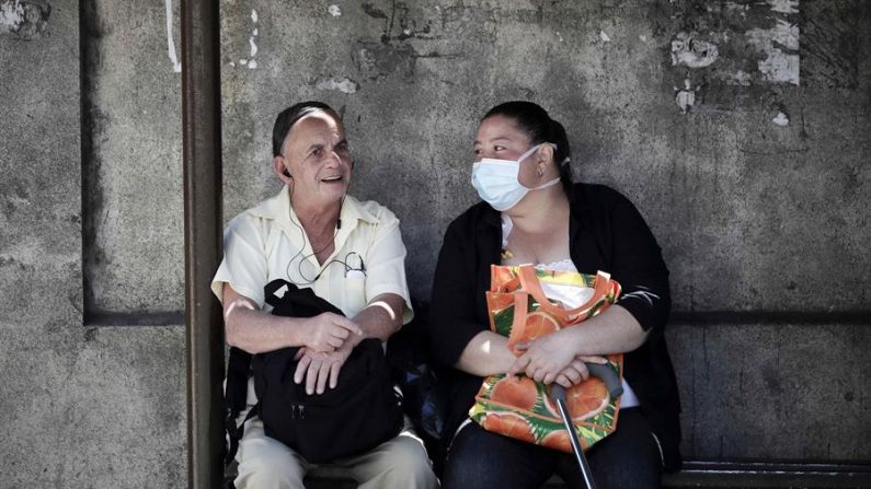 Una mujer usa una mascarilla mientras conversa con un hombre el 10 de marzo de 2020 en San José (Costa Rica). EFE/Jeffrey Arguedas
