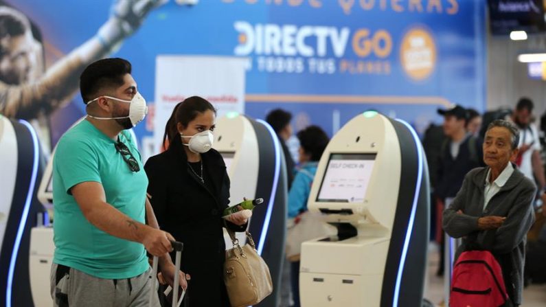 Viajeros utilizan mascarillas en el Aeropuerto internacional Mariscal Sucre de la capital. EFE/José Jácome/Archivo
