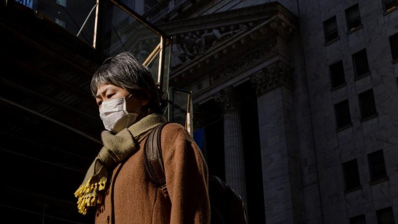 Una persona con una máscara facial camina por Wall Street pasando la Bolsa de Nueva York en Nueva York, Nueva York, EE.UU., el 03 de marzo de 2020. EFE/EPA/Justin Lane
