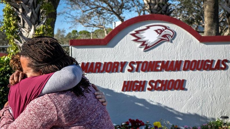 Dos mujeres se abrazan frente al monumento improvisado en conmemoración del tiroteo en el instituto Marjory Stoneman Douglas, en Parkland, Florida (Estados Unidos). EFE/ Cristobal Herrera/Archivo
