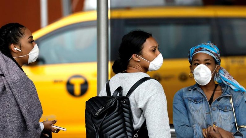 Las mujeres que llegan de Jamaica llevan máscaras protectoras en el exterior de la terminal internacional del aeropuerto Kennedy de Queens, Nueva York (EE.UU.), 12 de marzo de 2020. EFE/EPA/PETER FOLEY
