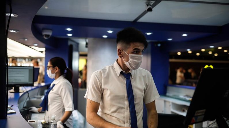 Pasajeros y empleados del Aeropuerto de Ezeiza se protegen con tapabocas tras el aumento de casos de coronavirus en Buenos Aires (Argentina). EFE/ Juan Ignacio Roncoroni
